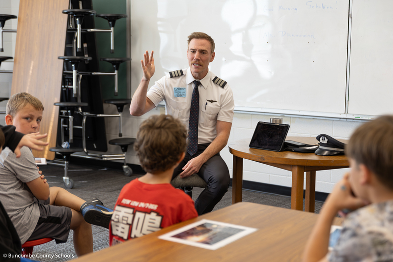 Pilot talking to a group of students.