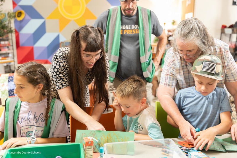 two teachers help students with craft