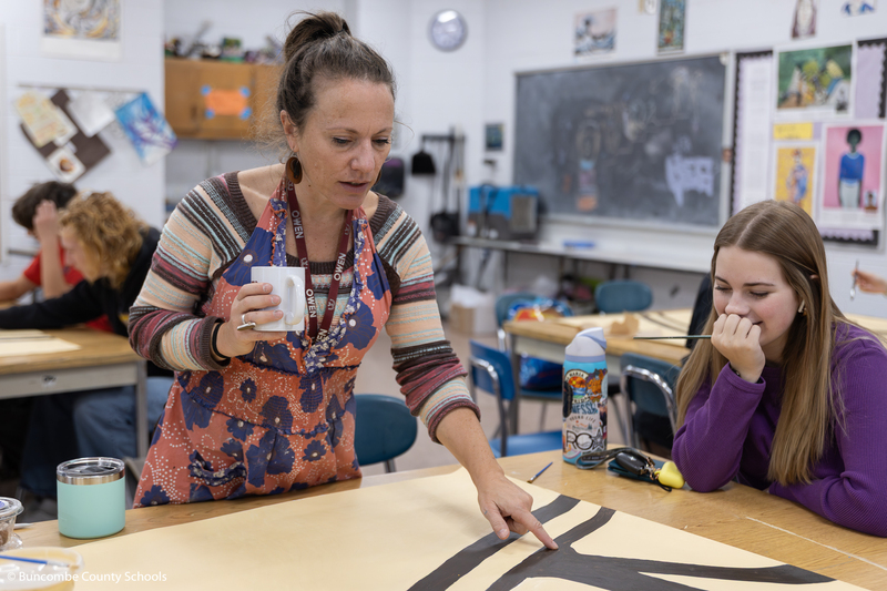 Ms. Birken helping students with the art mural.