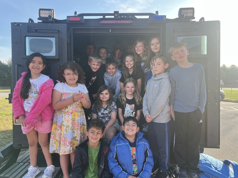 Group photo of kids in the back of the Bearcat car from the Buncombe County Sheriff's Office.