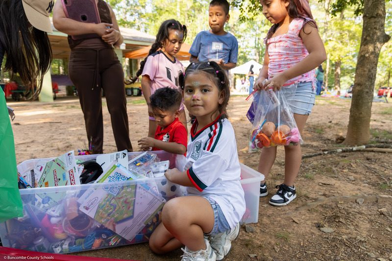 A girl with her face painted looks at the camera.