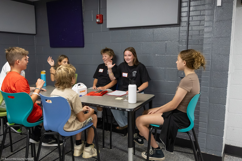 Eighth grade mentors talk to rising sixth grade students in the Owen Middle cafeteria.