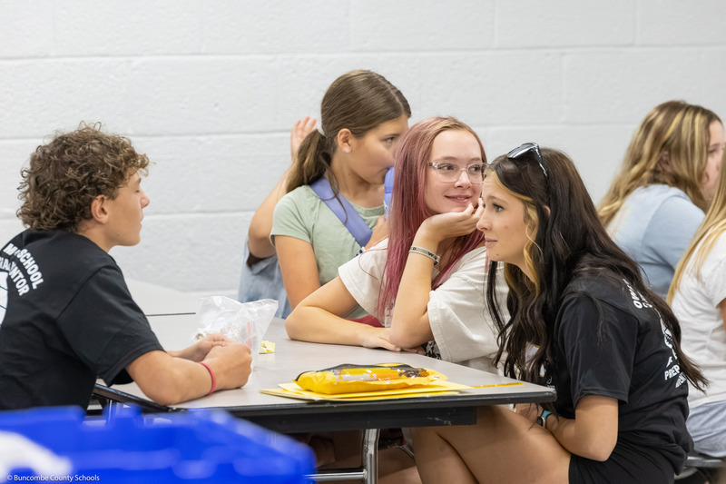 A girl smiles as she looks over her left shoulder.