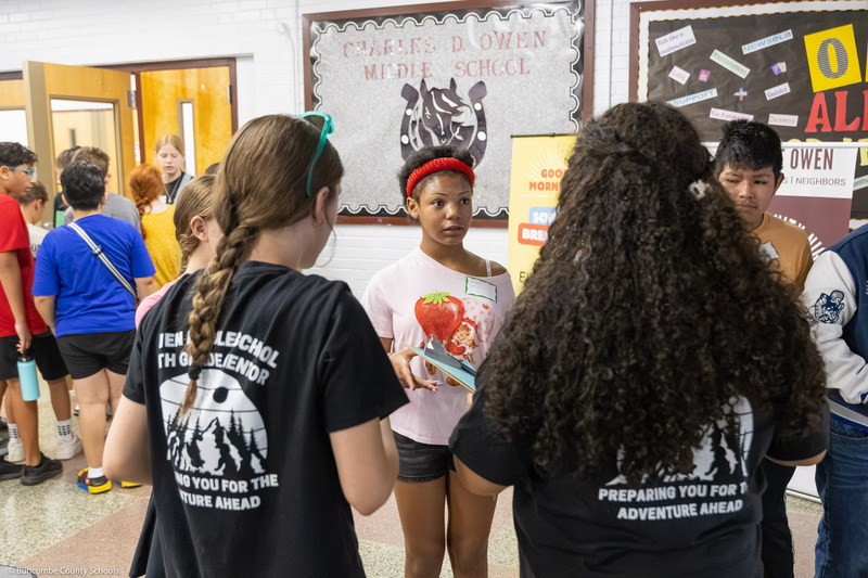 A sixth grade girl talks to a group of sixth and eighth graders.