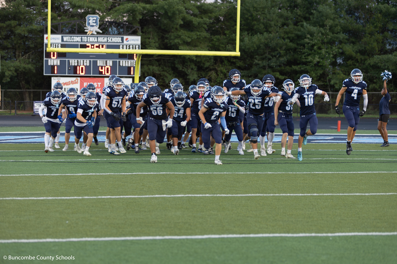 The football team running on to the field at the start of the game.