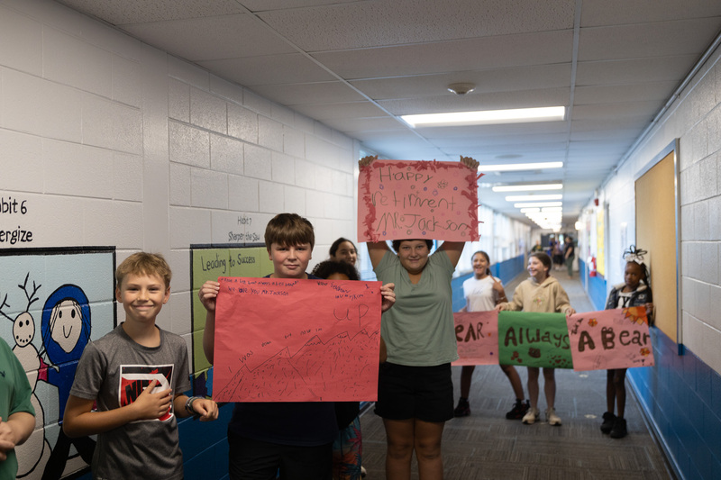 Students line the hall holding congratulatory signs for Dr. Jackson.