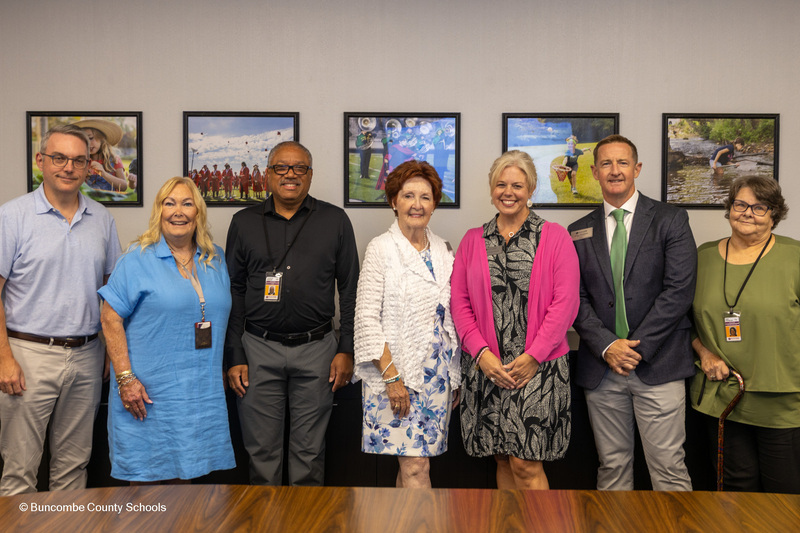 Dr. Reed poses for a photo surrounded by school board members and the board attorney.