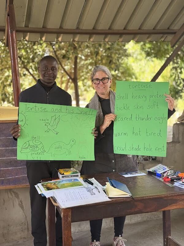 Ms. Shields with a man both holding posters about turtles. 