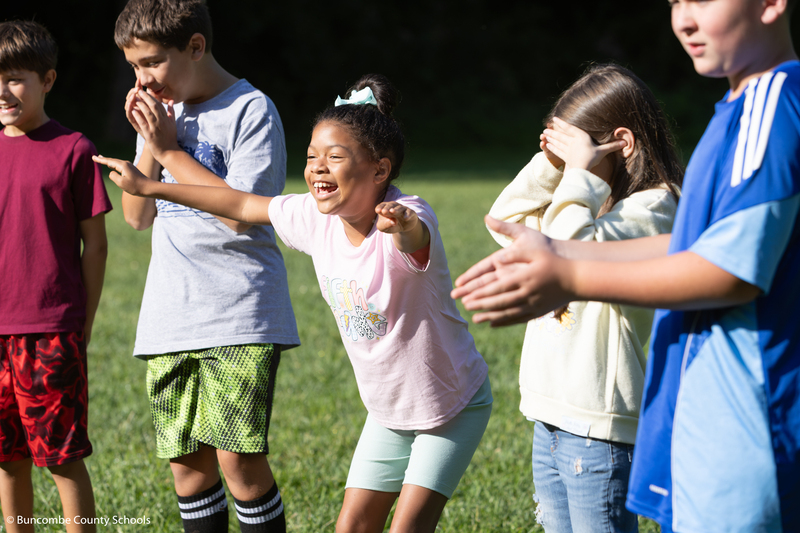 Group of kids cheering on their teammates. 