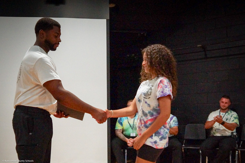 A girl in a tye-dye shirt shakes hands with an SRO.