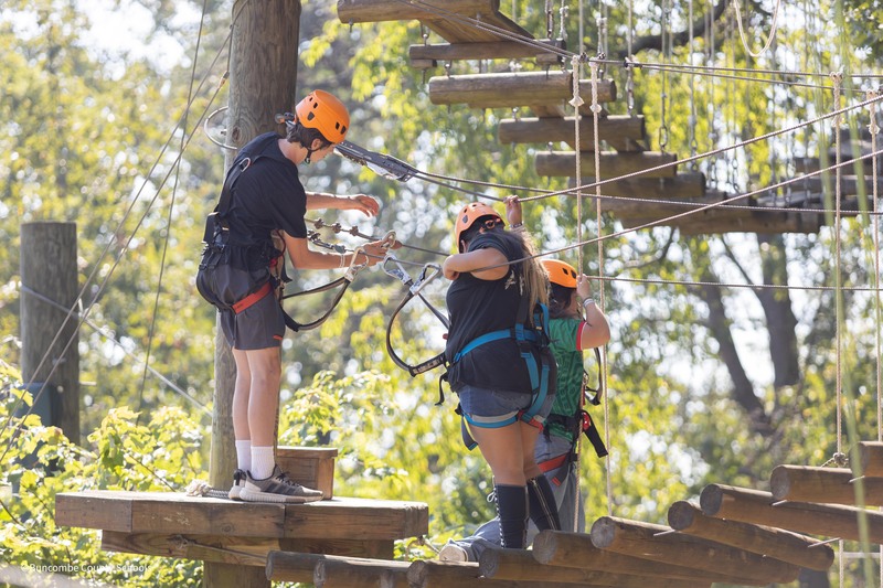 students working together on ropes course.