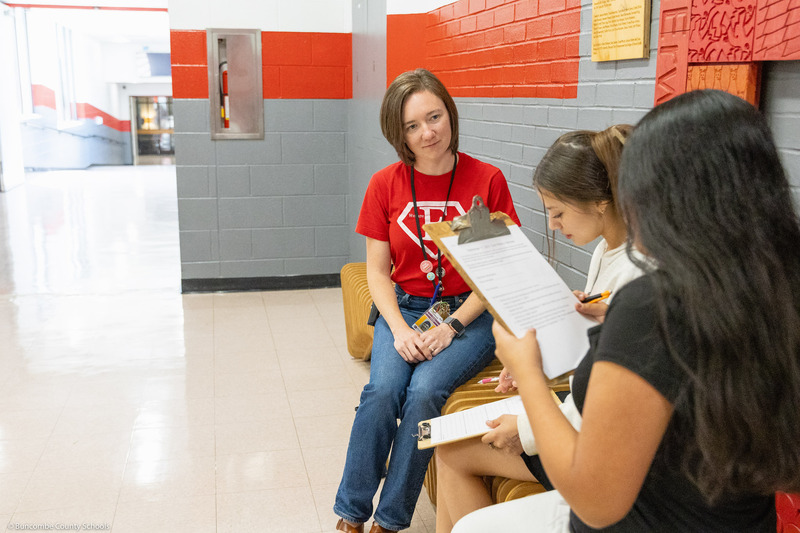 A teacher listens while students ask questions.