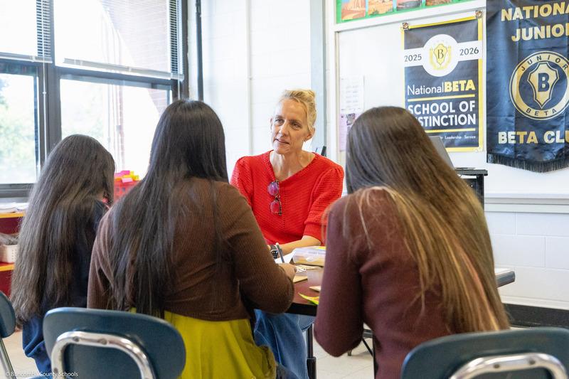 A teacher listens while students ask questions.