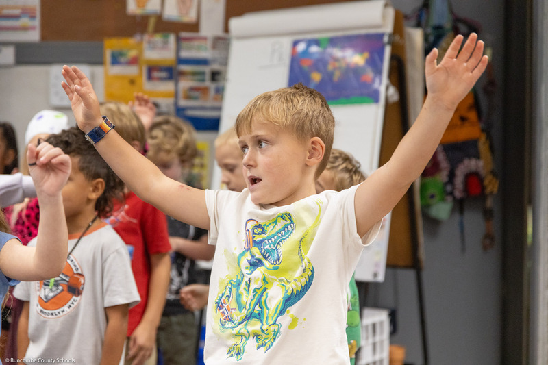 Students move their hands while singing "The Dot Song."