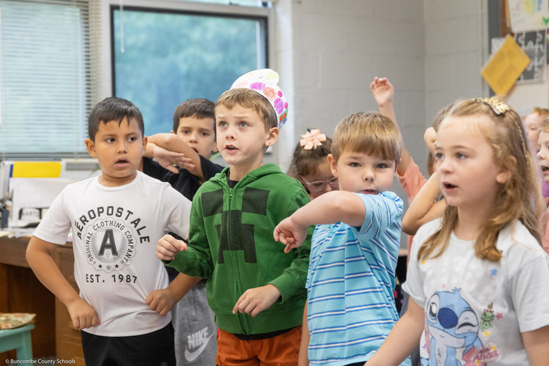 Students move their hands while singing "The Dot Song."
