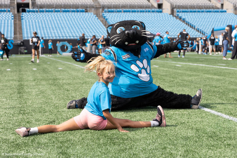 Student doing a split with Sir Purr