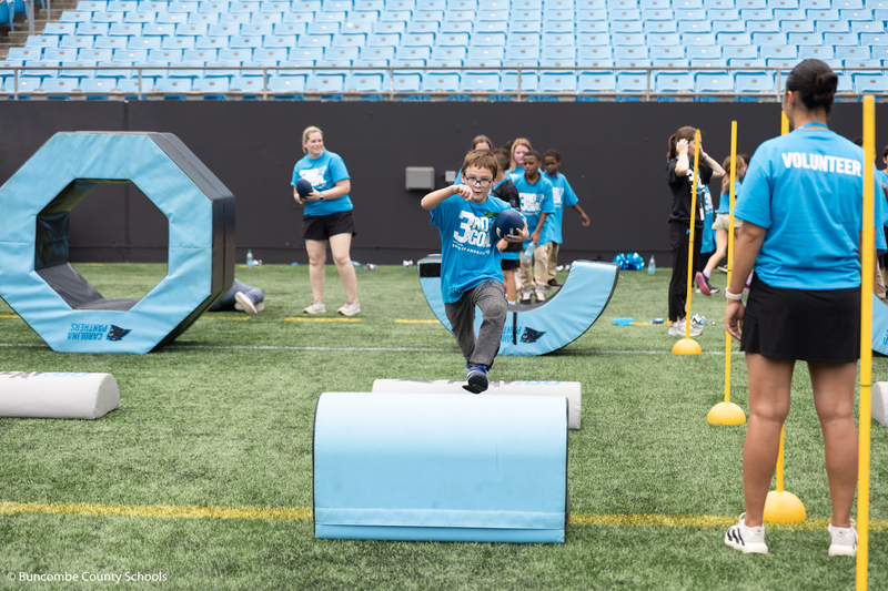 Kid running with a football in hand.
