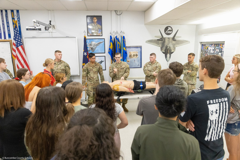 Members of the U.S. Army Traveling Medical Team speaks to students behind a mannequin.