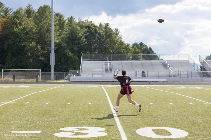 woman running to catch football