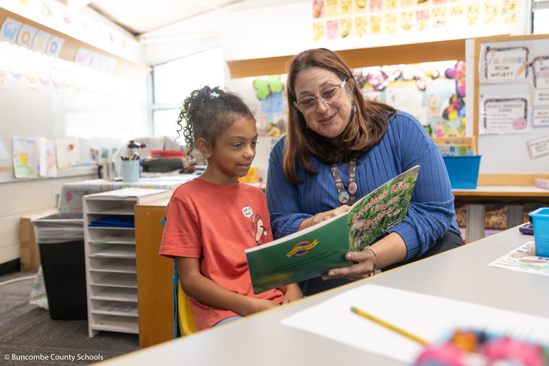 Ms. Buckner reading to a student.