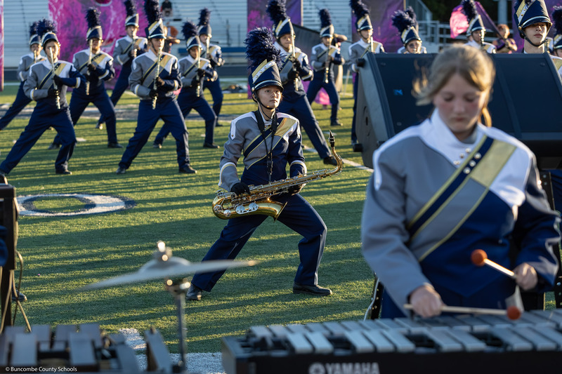 A T.C. Roberson High saxophonist leans as part of a marching configuration.