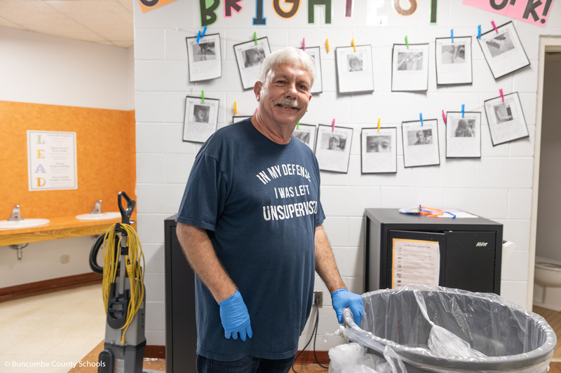 Mr. Allison pushing a trash can.