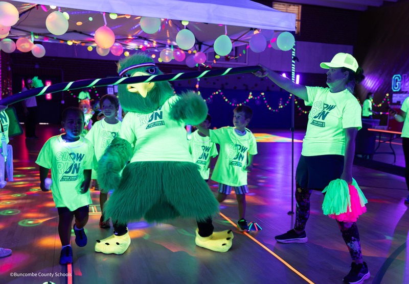 Haw creek hawk limbos with students at glow run