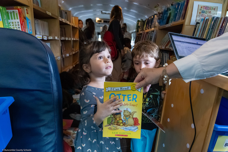 A pre-k student checks out a book in the BCS Bookmobile.