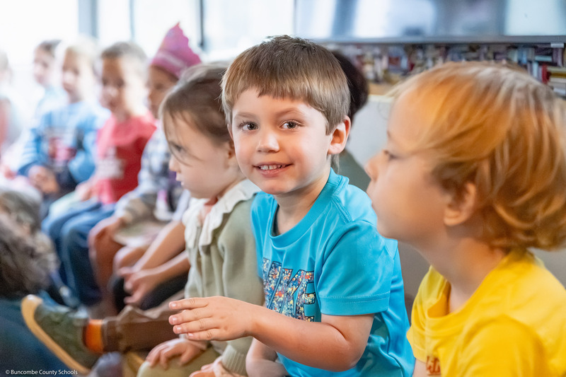 A pre-k student smiles inside the BCS Bookmobile.