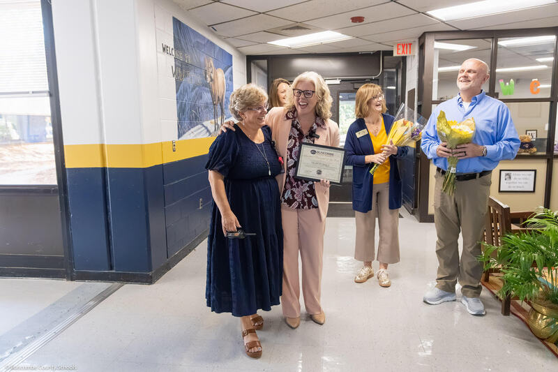 Superintendent Dr. Jennifer Reed surprising Margo in the front lobby.