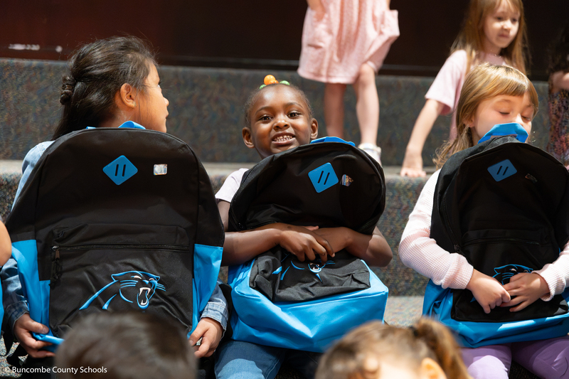 student hugging her new backpack.