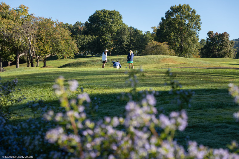 three golfers on the green