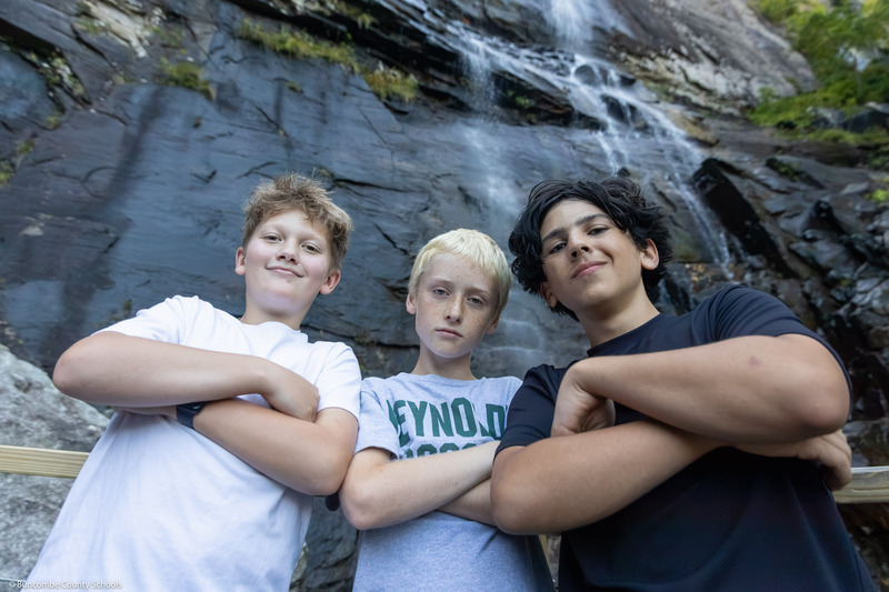 A group of A.C. Reynolds Middle School seventh grade boys stand, arms crossed, on the Hickory Nut Falls viewing platform.