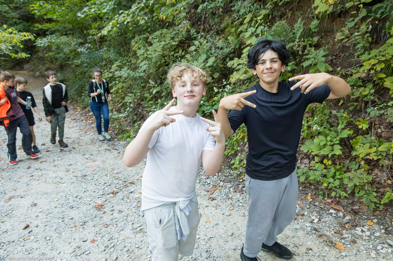 Two students hold up peace signs on the trail.