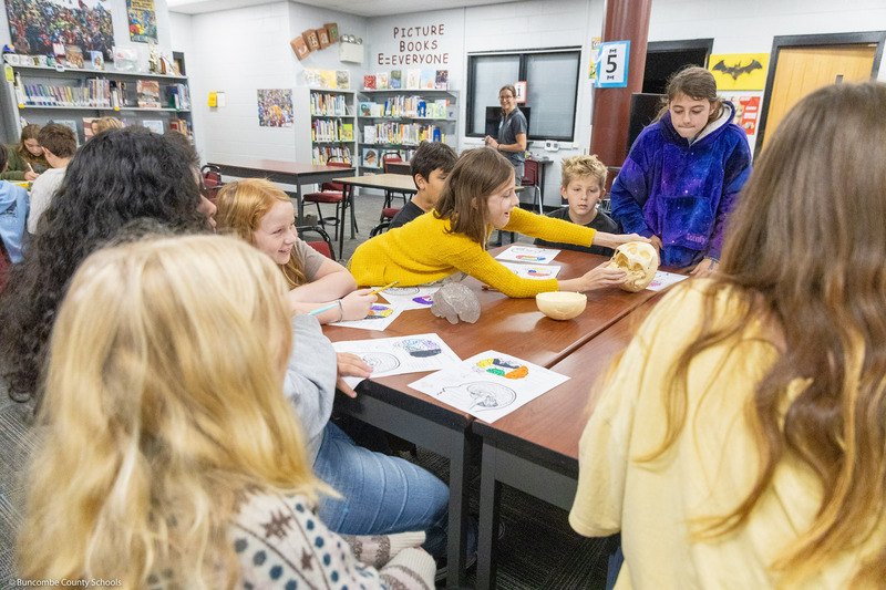 Warren Wilson students sit around a table and lead a project with Black Mountain Elementary students.