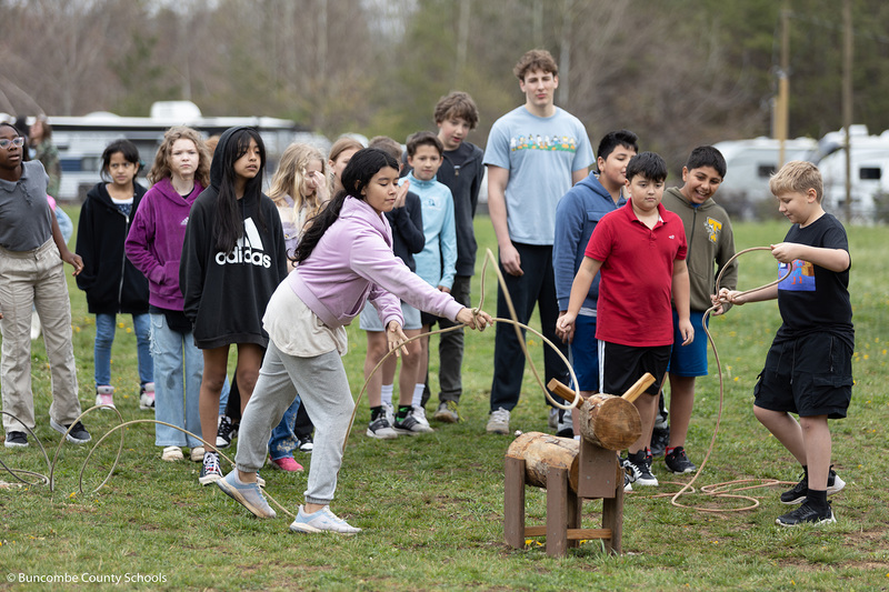 Students practice ripping a wooden cow figure. 