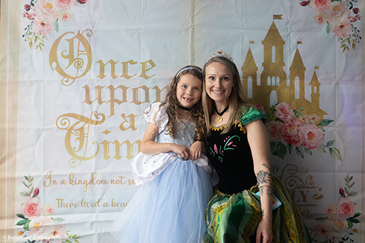 Student dressed as Cinderella posing with her teacher who is dressed like Ana from Frozen. 