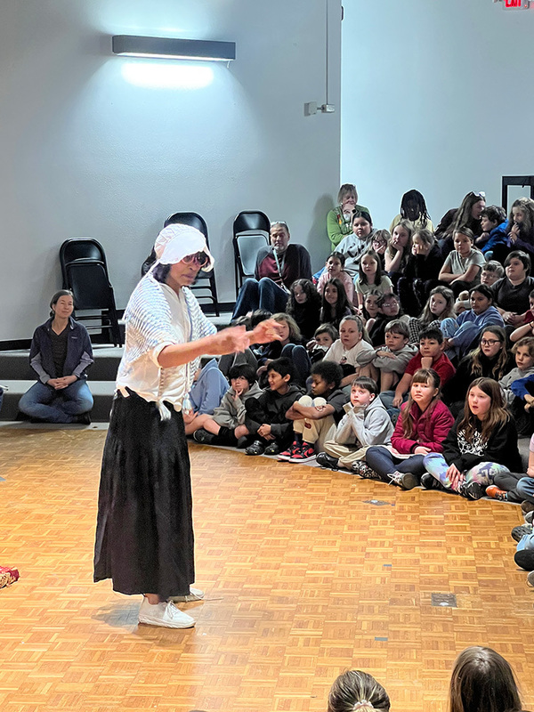 Female actor telling a story to students. 