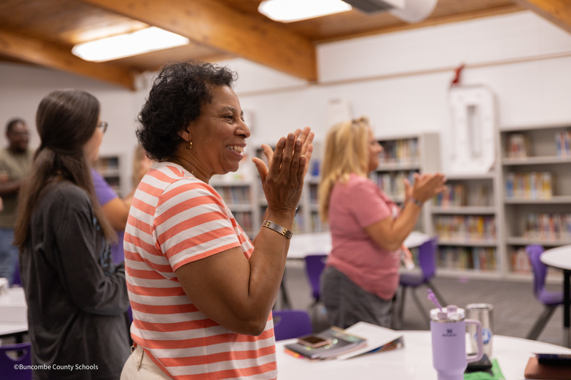 Teachers stand and applaud in the Emma Elementary media center