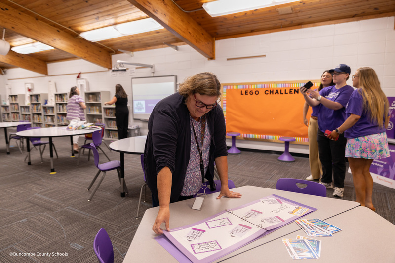 Mrs. Pollard reads notes of encouragement from Subaru customers from a scrapbook on a table in the Emma media center