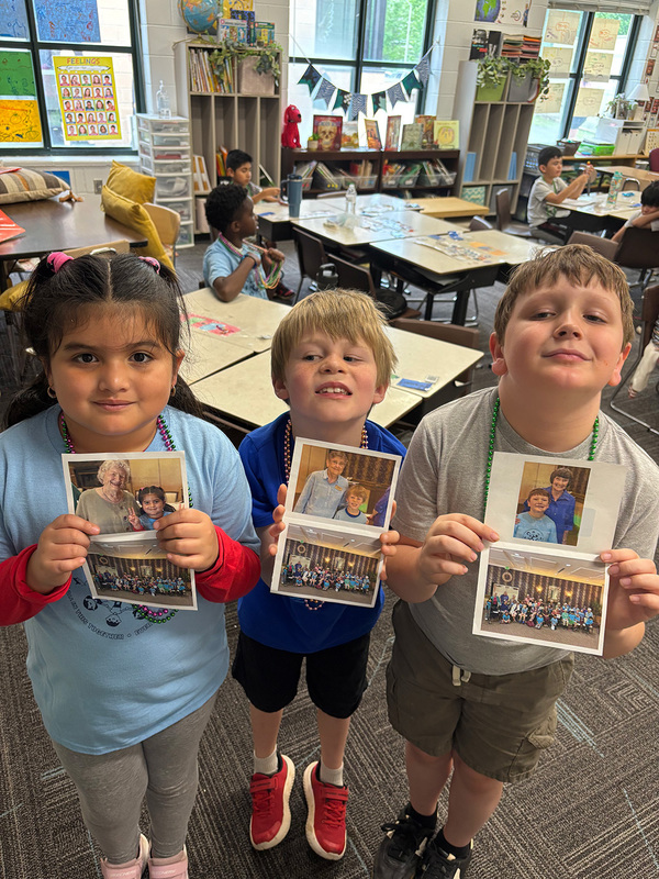 Group of three students holding up photos from their visit at Ardenwoods. 