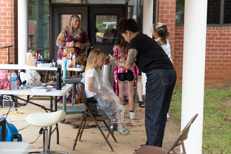 Several students getting their hair cut. 