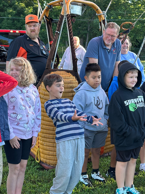 Students excited to see a hot air balloon at school. 