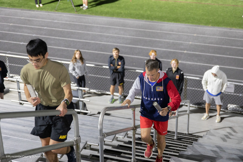 JROTC student and Dr. Jackson running on stadium stairs