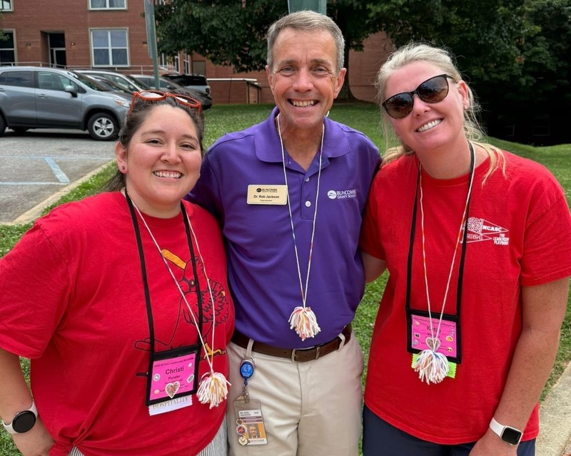 Dr. Jackson poses for a photo, standing between two student council advisors