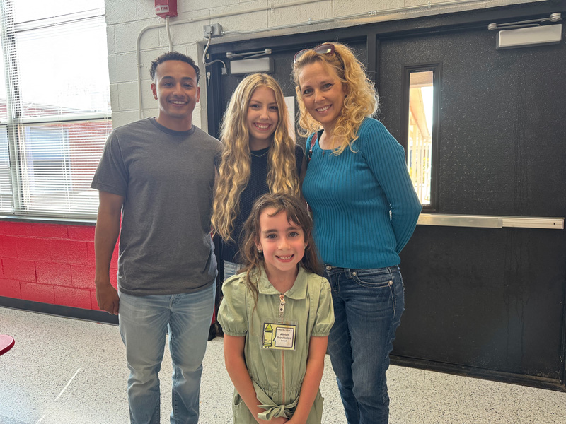 Family photo of mom, two sisters and brother in law in the cafeteria. 