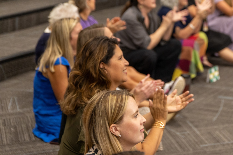 Close-up of two teachers applauding.