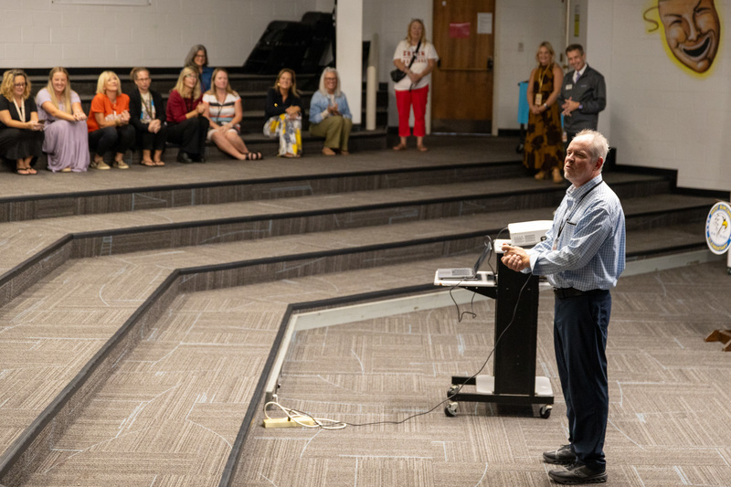 Mr. Johnson stands at the podium, addressing teachers seated in the theater.