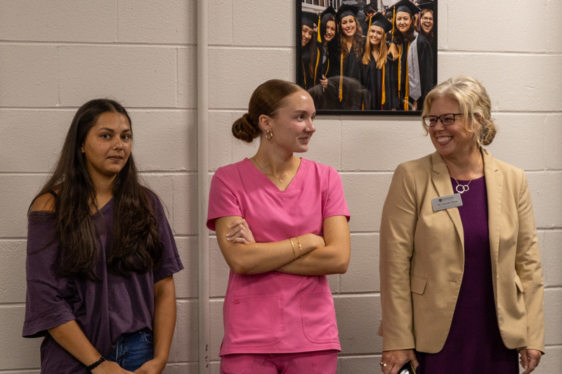 Dr. Reed stands next to two students at the Student Advisory Council meeting