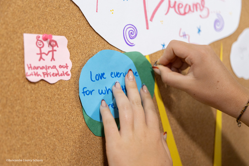 student hanging her hopes and dreams on cork board